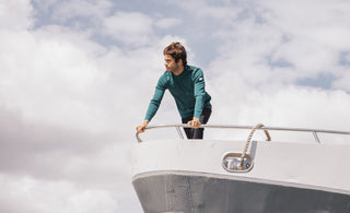 Photo d'un homme portant un pull marin MARCEAU couleur Diaobolo sur la pointe d'un bateau.