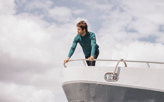 Photo d'un homme portant un pull marin MARCEAU couleur Diaobolo sur la pointe d'un bateau.