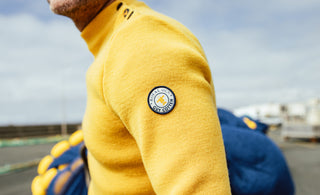 Homme portant un pull marin uni jaune de la collection Royal Mer x Guy Cotten.